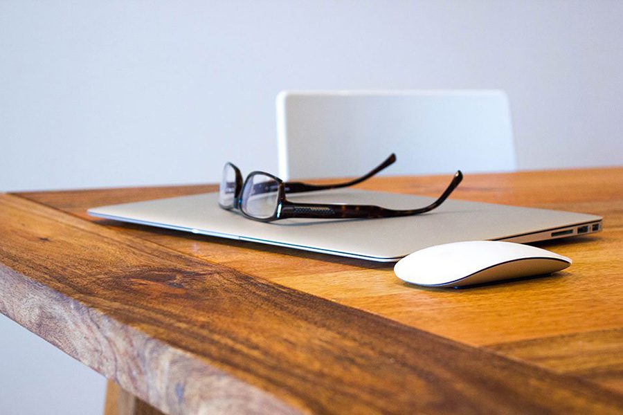 Blog - View of Laptop Mouse and Glasses Sitting on Wooden Desk