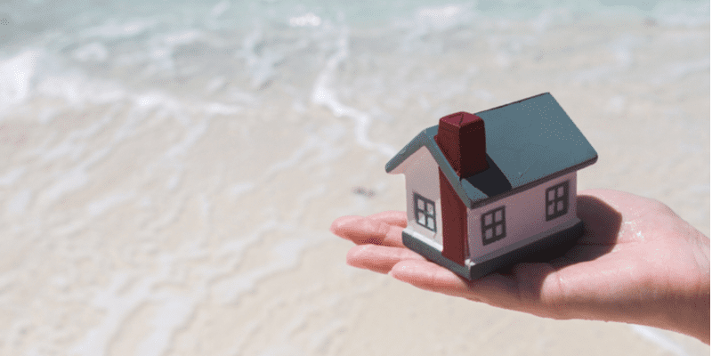 house on a beach surrounded by water